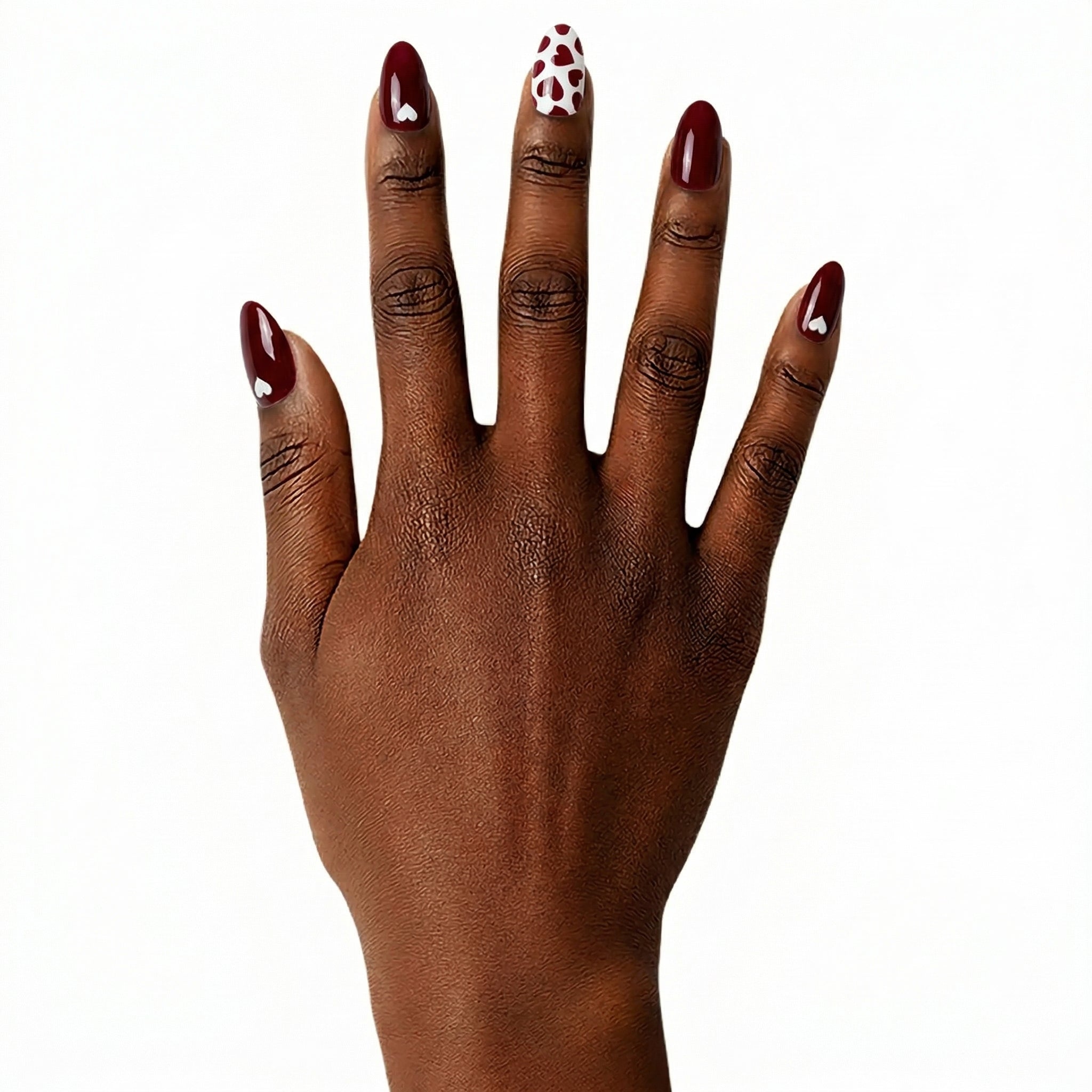 Main peau foncée avec ongles longs rouge bordeaux et motifs cœurs blancs Glamisu, manucure élégante brillante sans UV