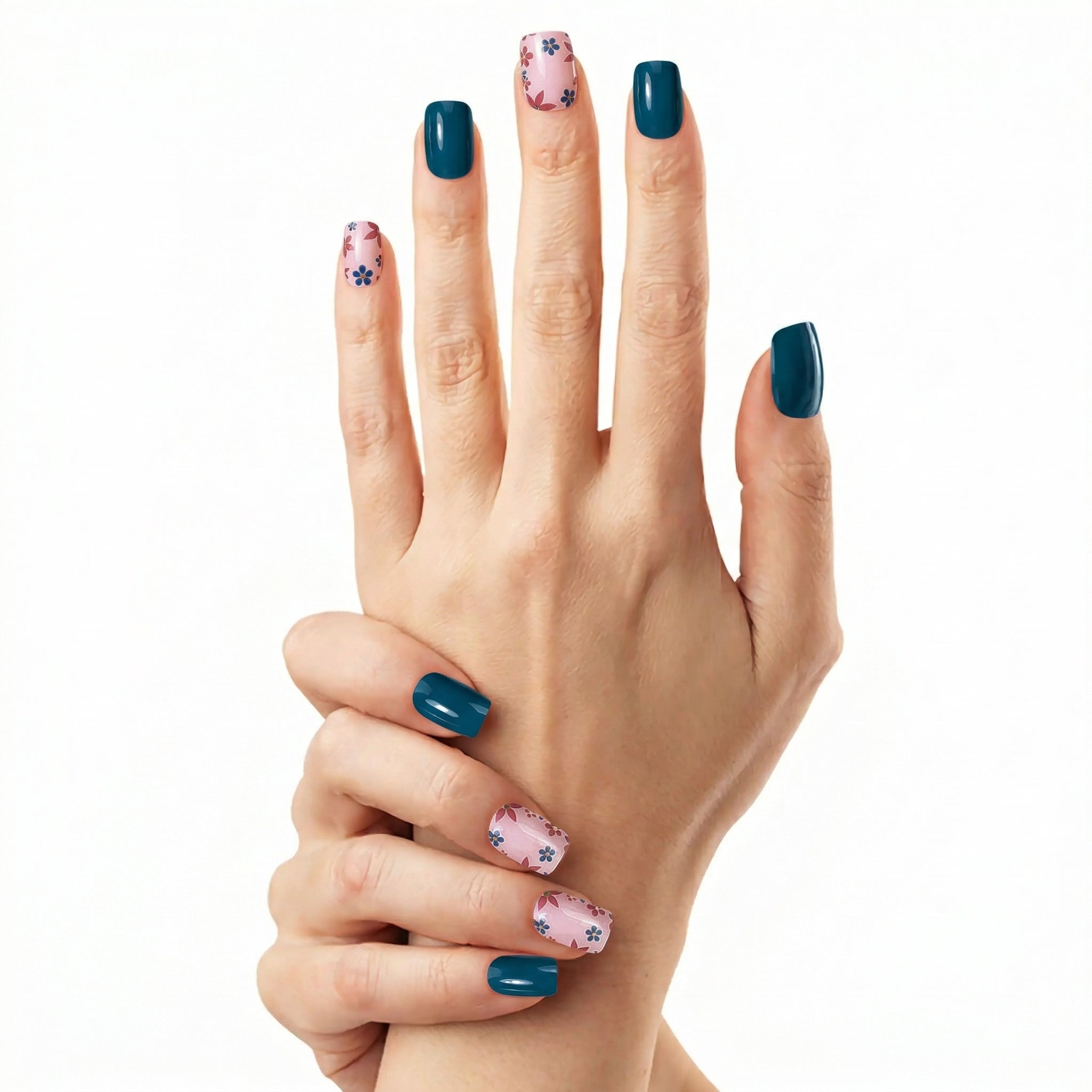 Détail manucure Glamisu bleu profond avec nail art floral rose sur ongles courts, finition brillante élégante sans UV