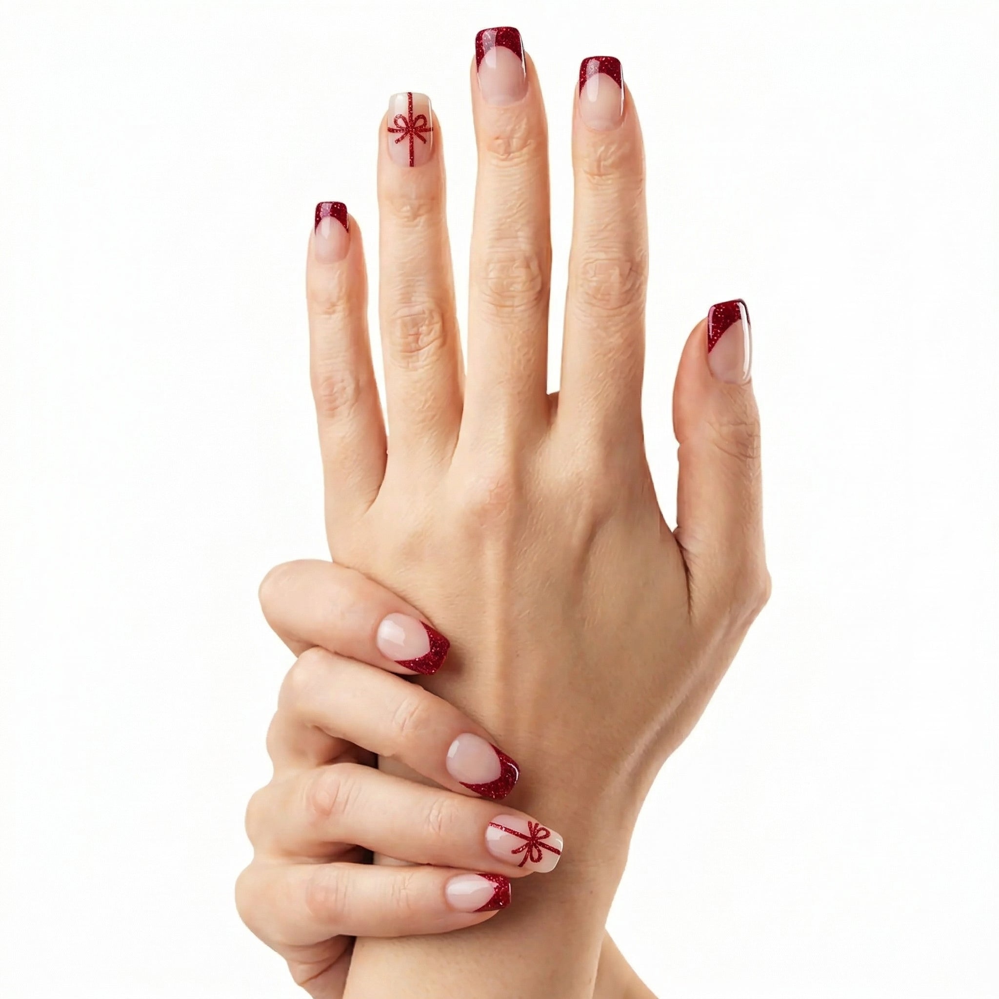 Duo de mains avec ongles courts nude Glamisu et french rouge pailleté avec motif nœud élégant, manucure festive sans UV